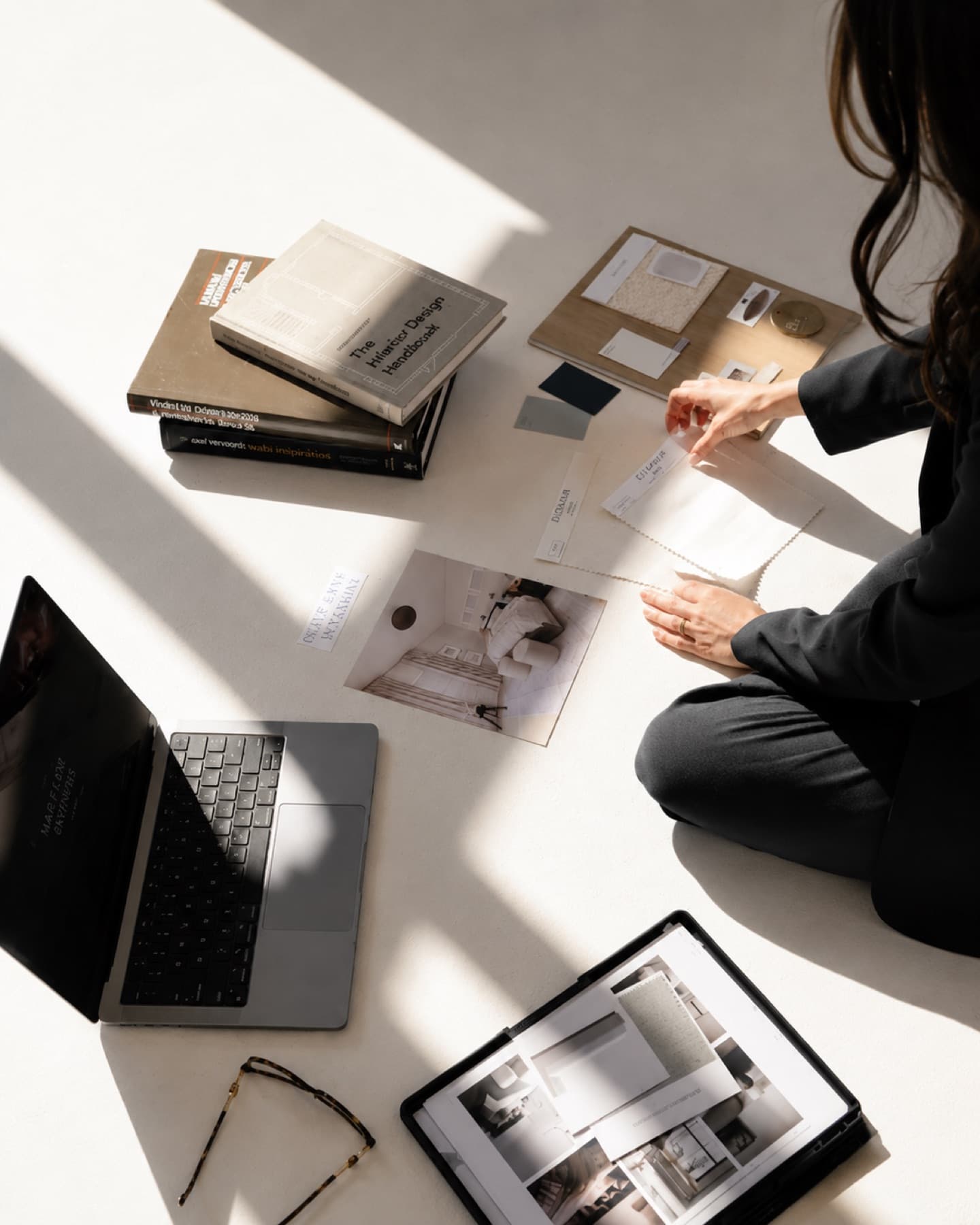 A planner laying out swatches and materials on a sunlit floor